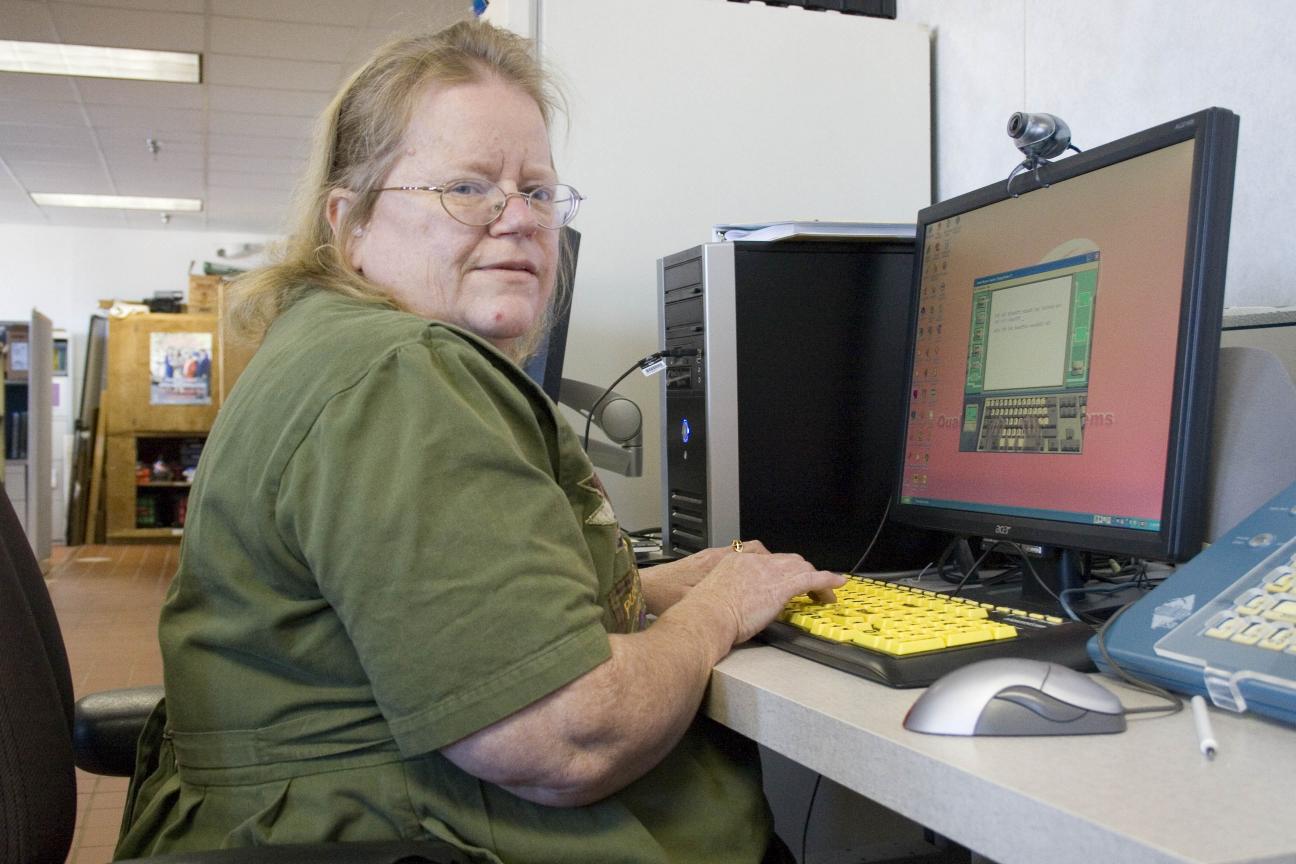 Woman using high contrast keyboard for accessibility at work.
