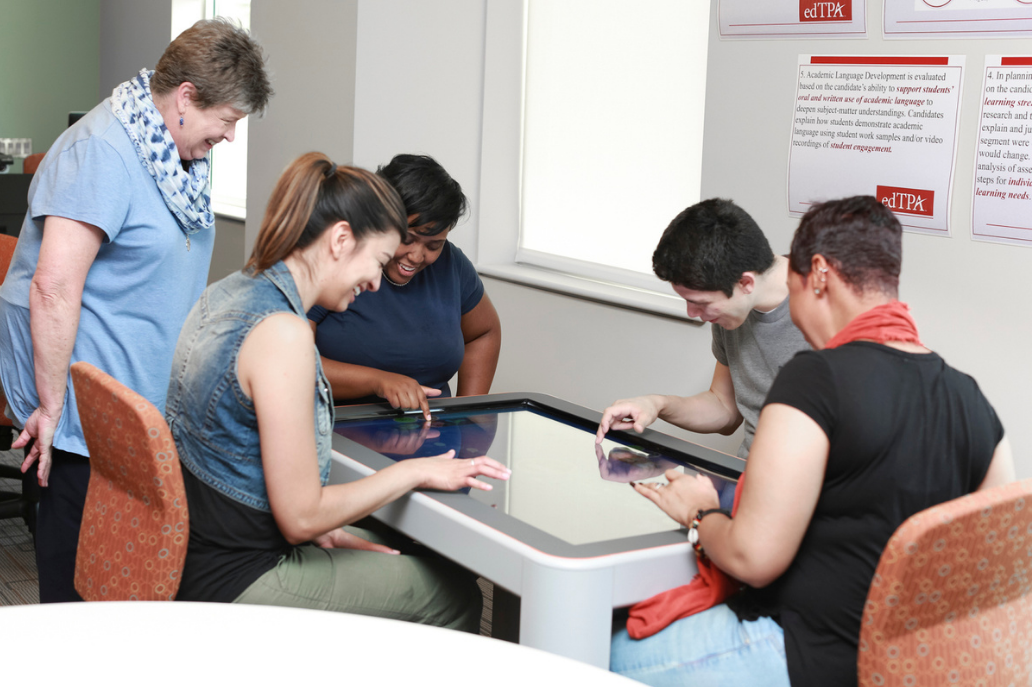 A group of students in a community center using assistive technology.